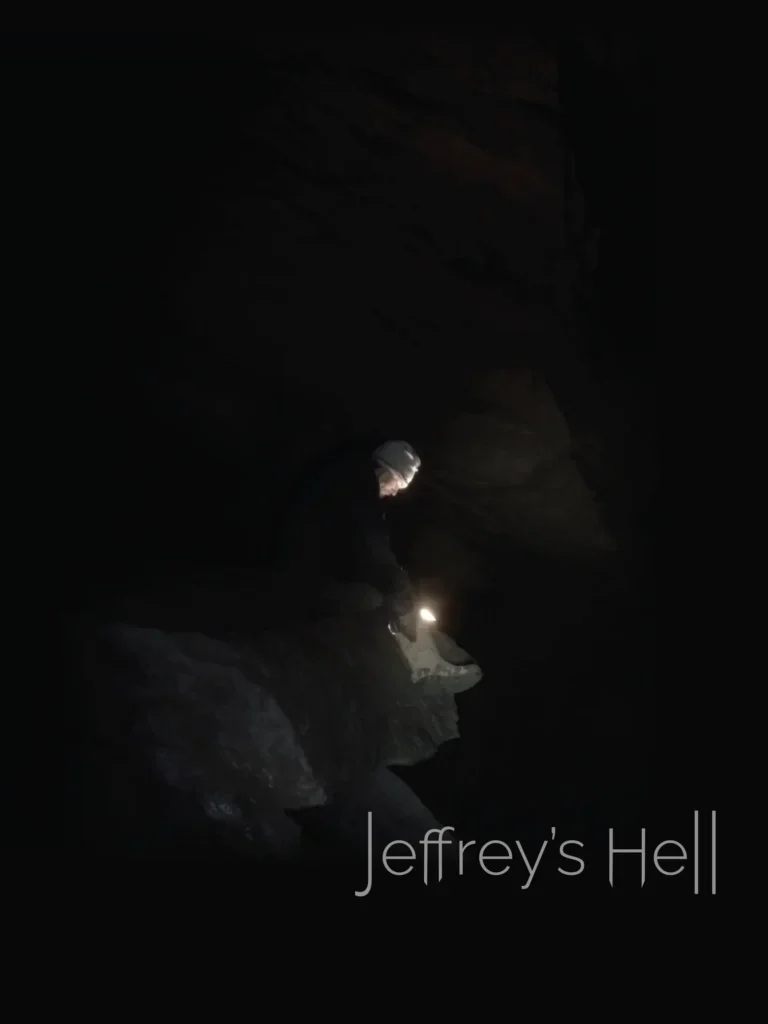 Póster oficial de Jeffrey’s Hell: una persona con luz en una cueva oscura